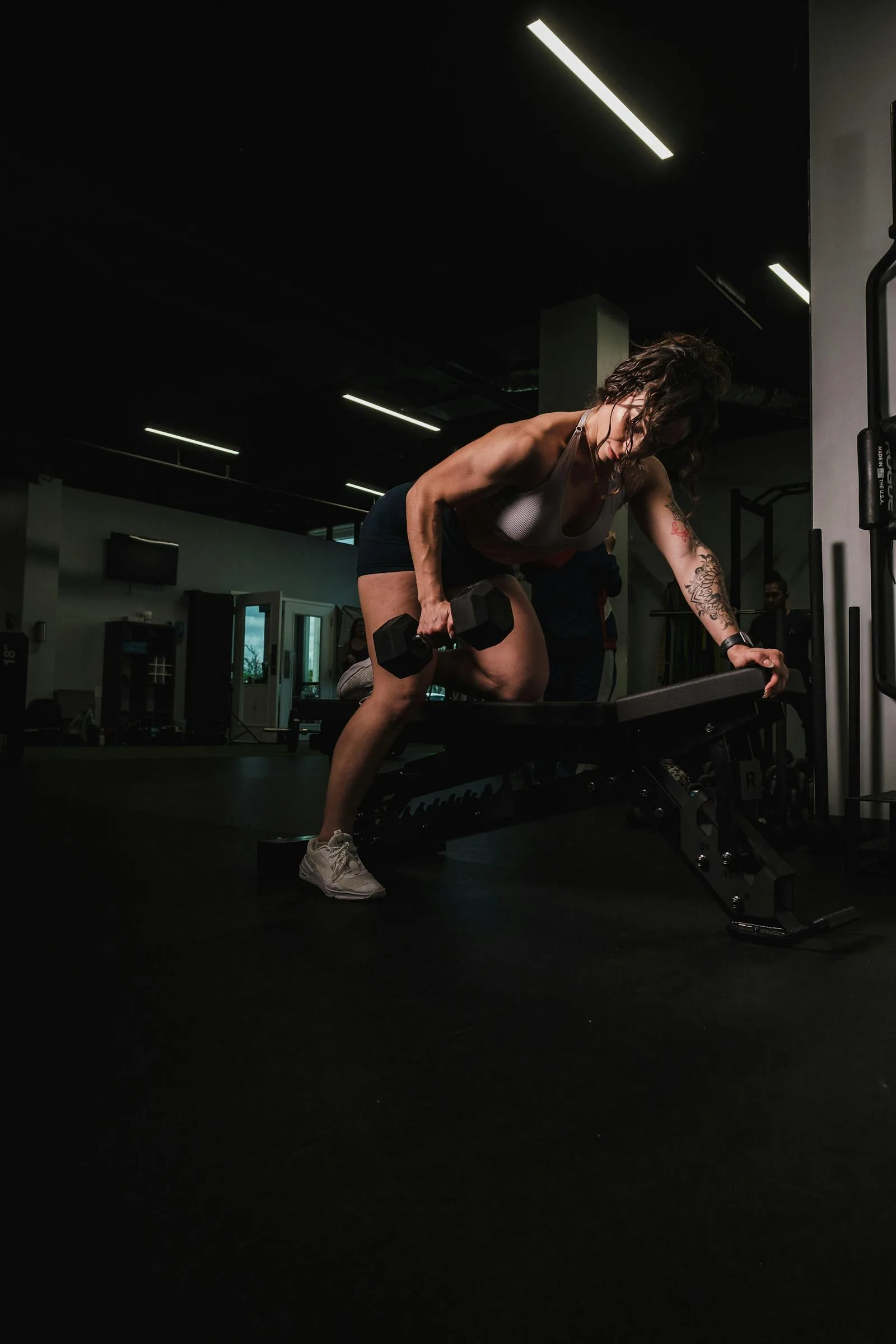 Woman lifting a dumbbell in a gym.