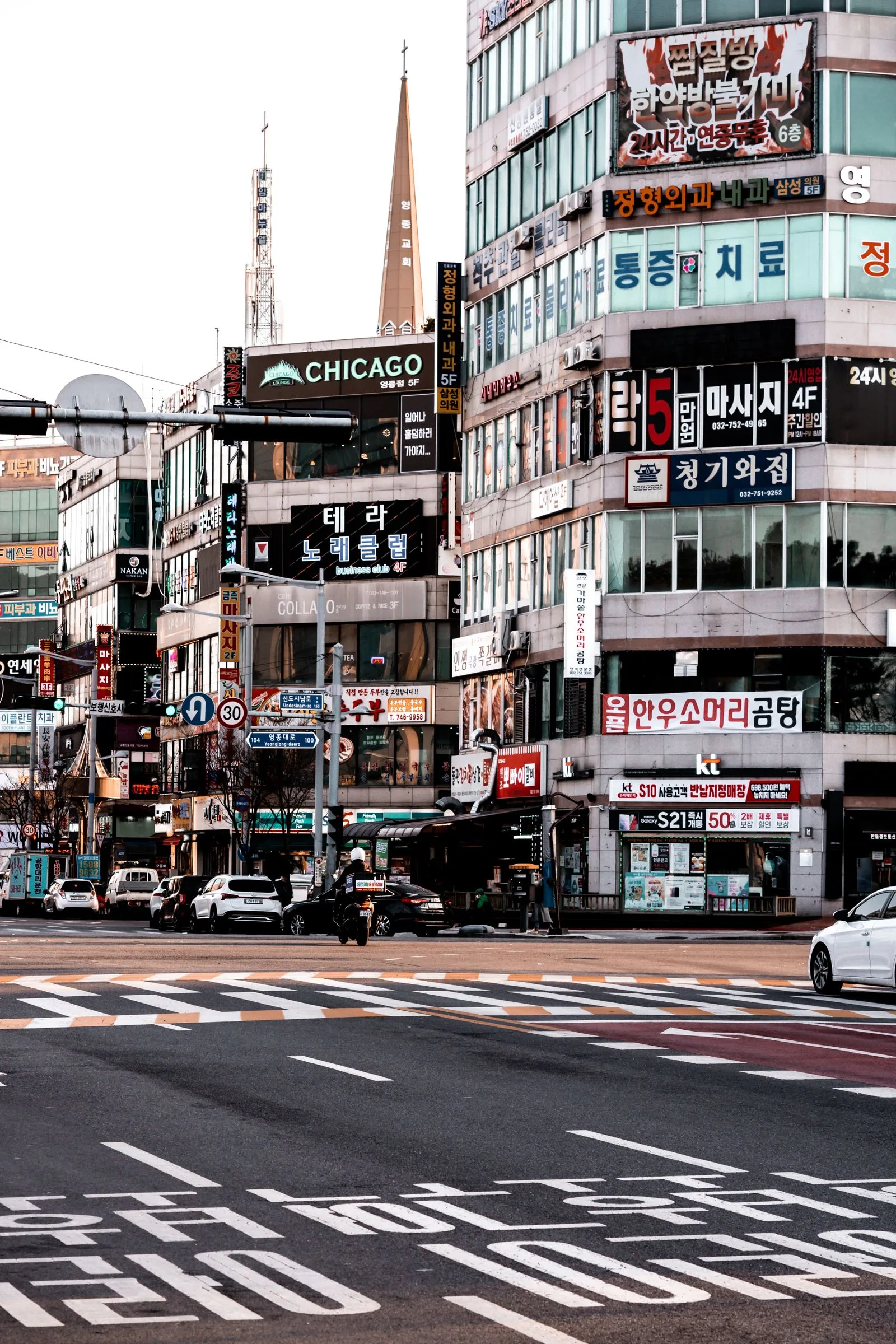 Seoul street intersection with buildings and Korean signage.