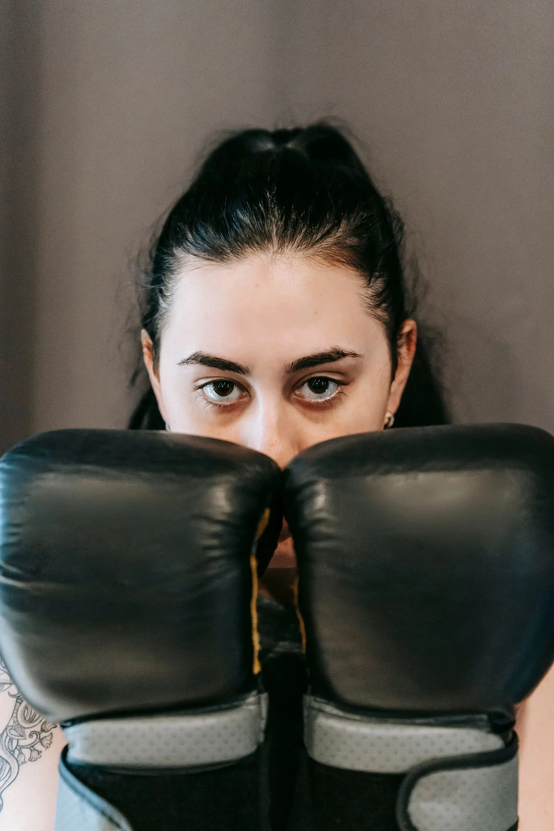 Front view of a boxer keeping both gloves up with a clear line of sight.
