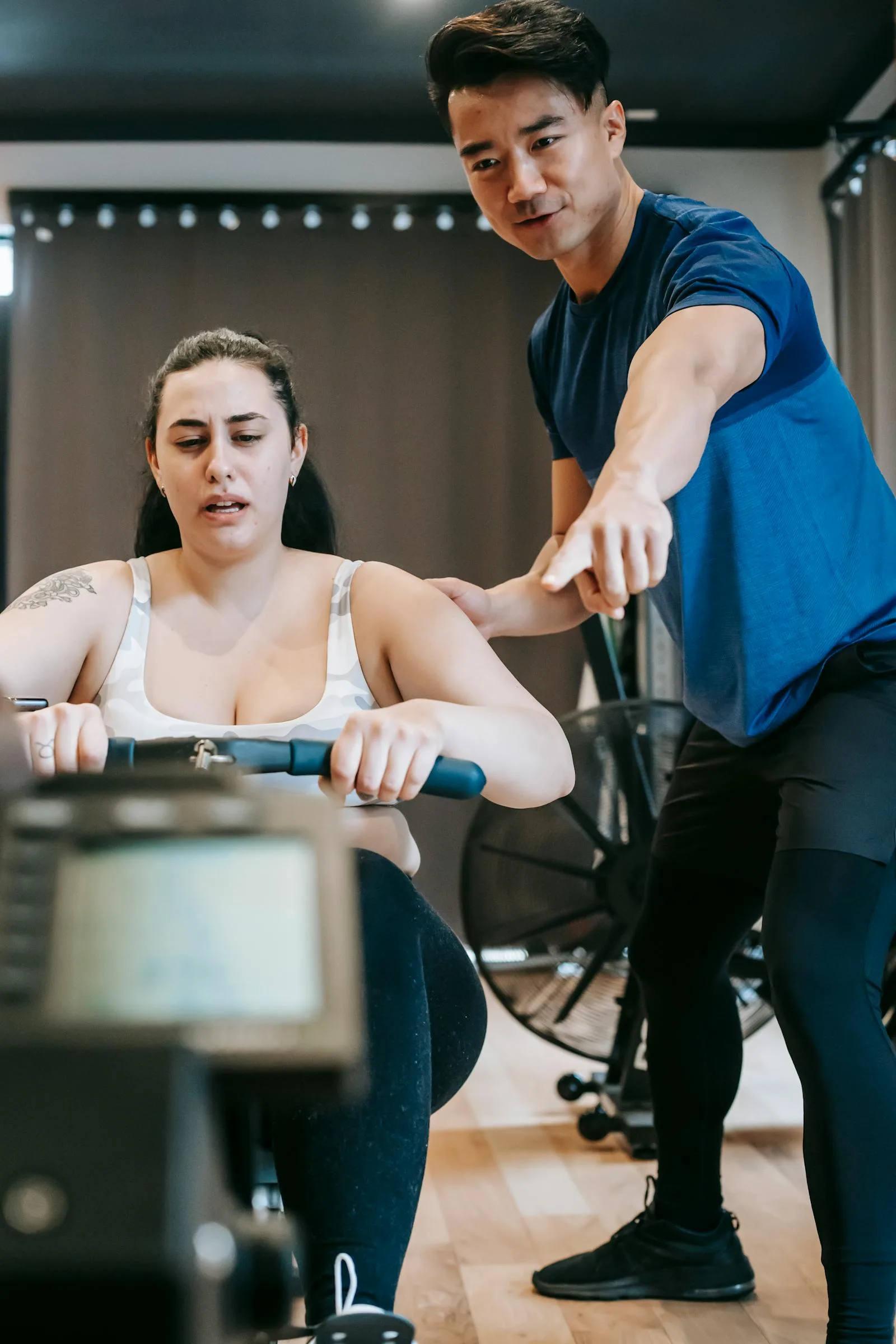 Personal trainer helping a client during a gym exercise.
