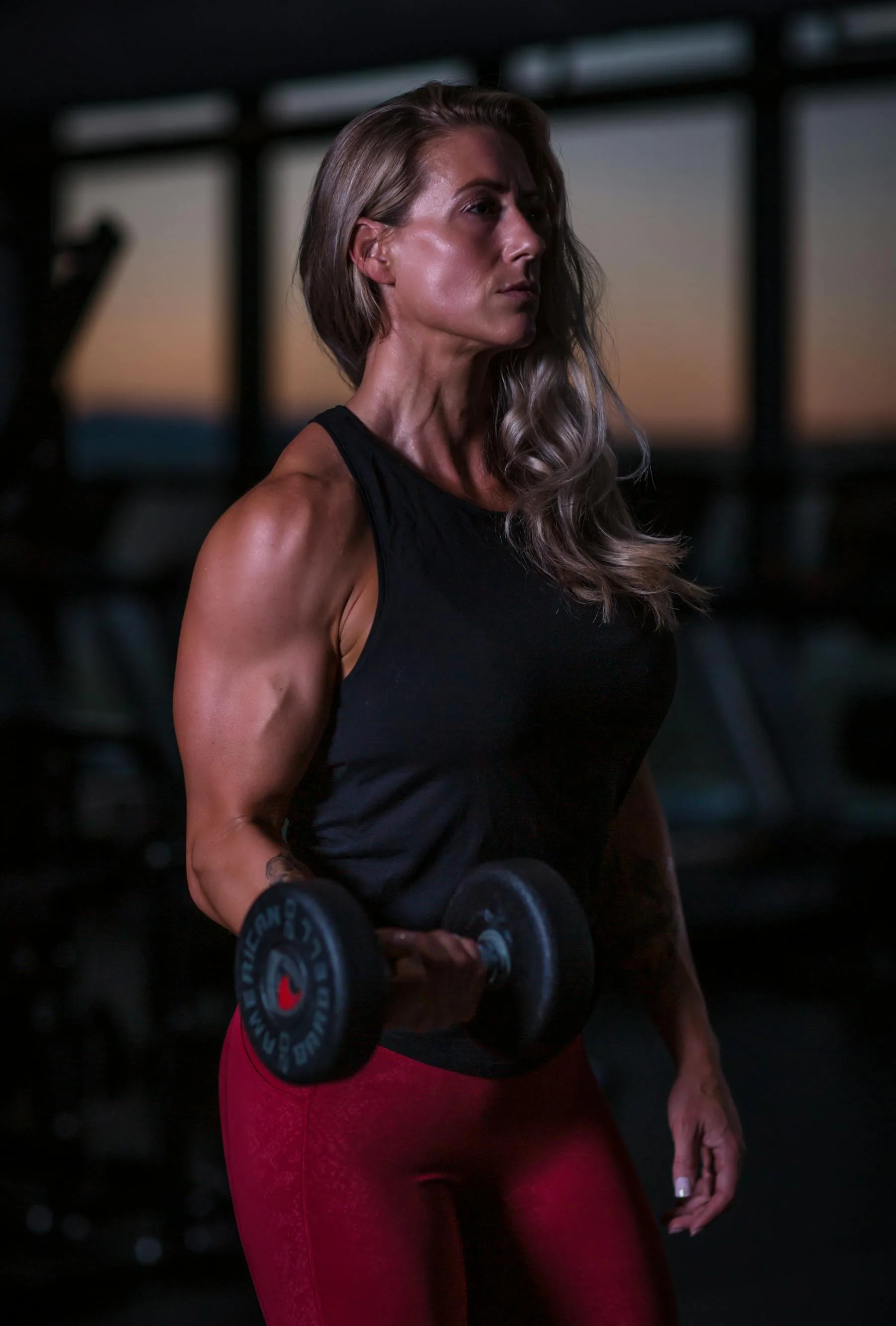 Woman lifting a dumbbell in a gym.