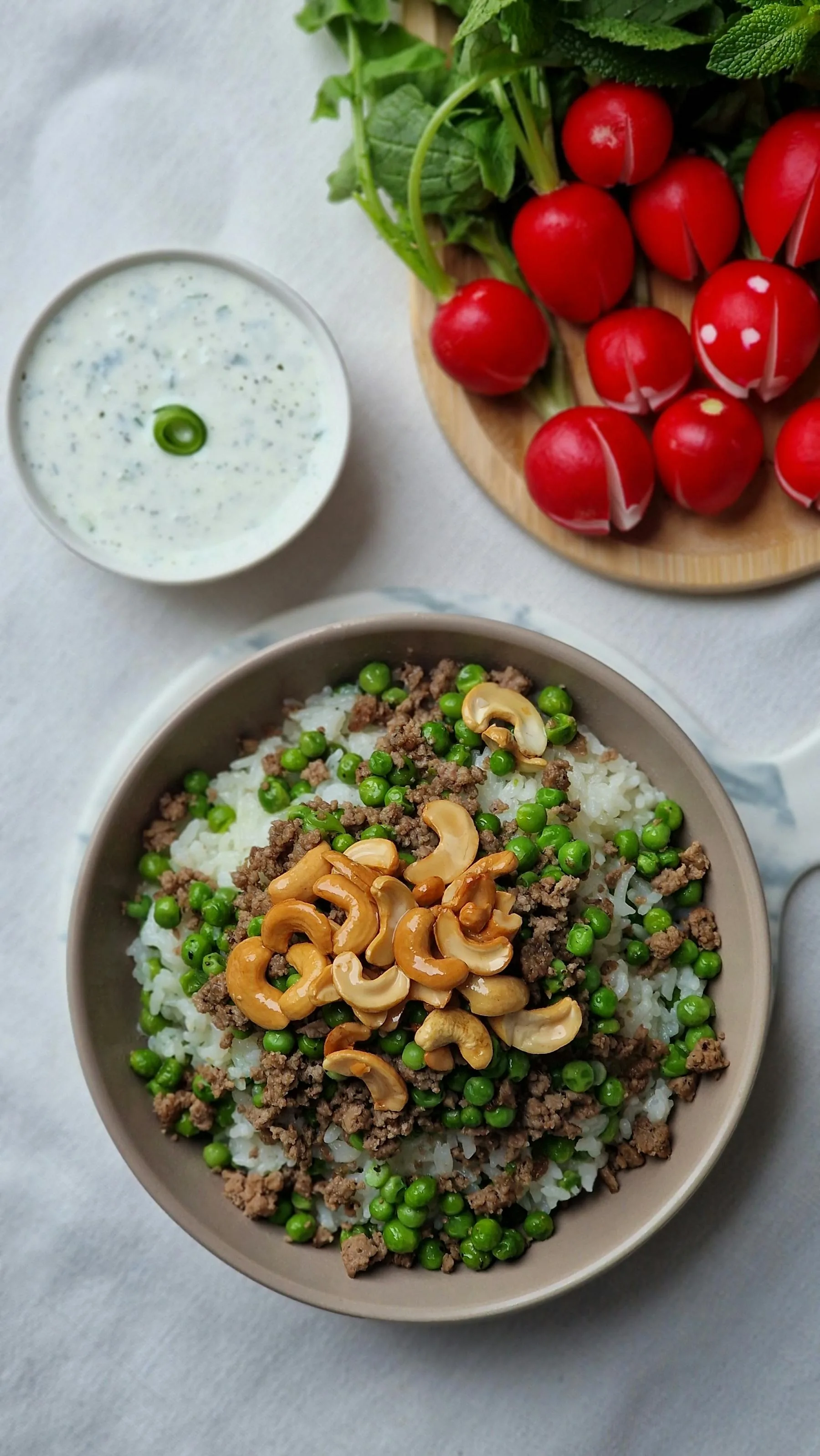 Rice dish with peas, nuts, and fresh vegetables.