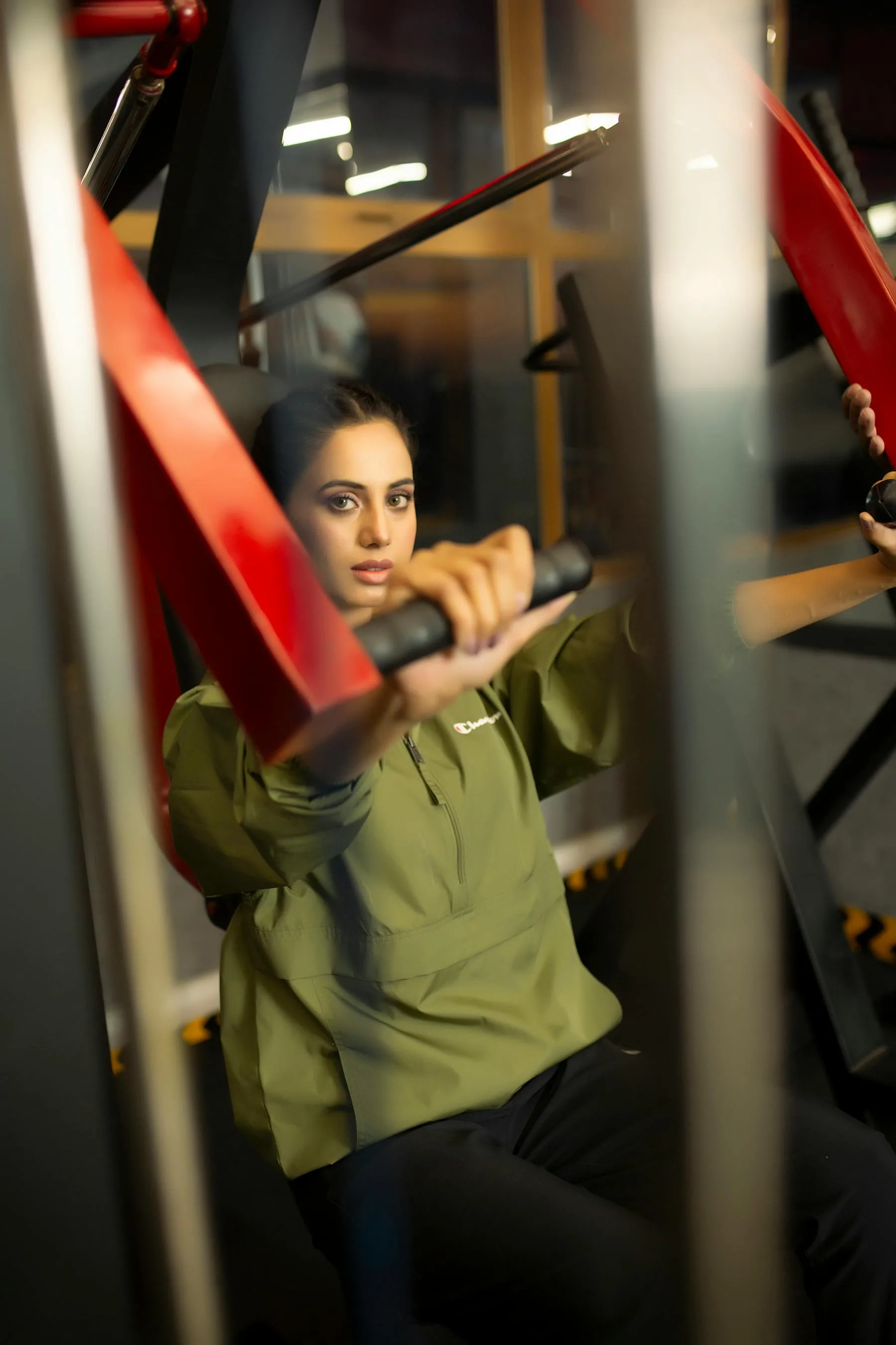Woman using gym equipment with a focused training posture.