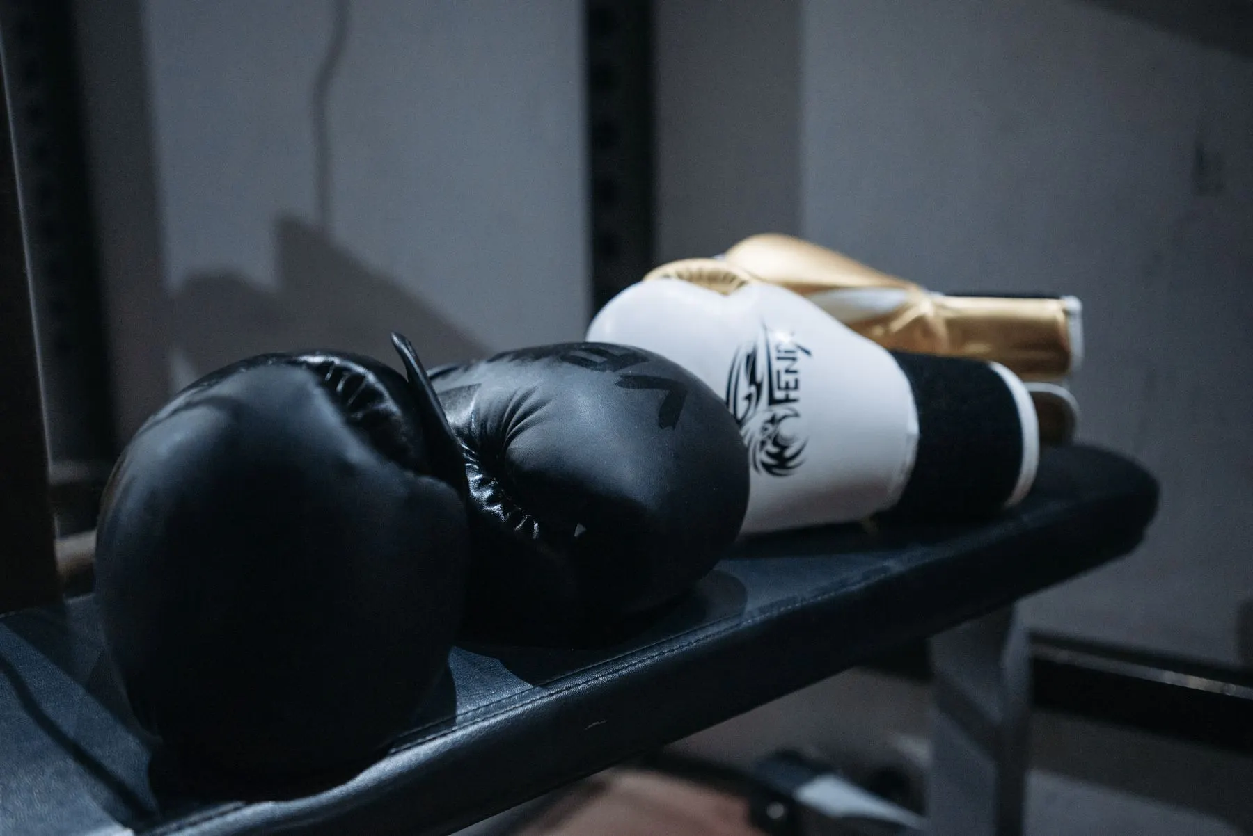 Two pairs of boxing gloves resting on a gym bench for a practical gear comparison.