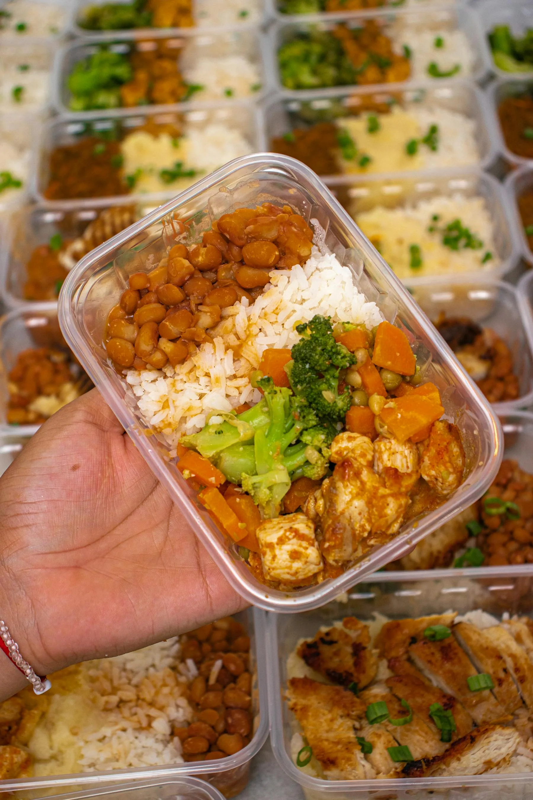 Meal prep container with rice, vegetables, beans, and chicken.