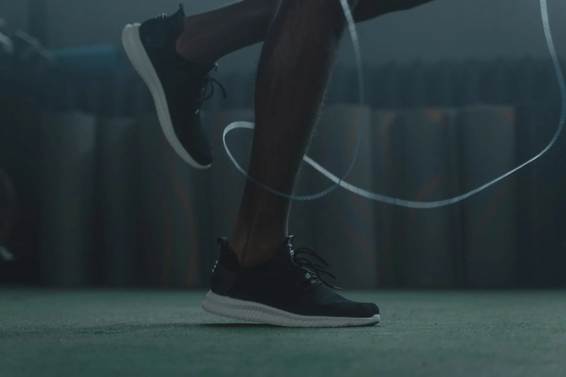 Close-up of low rope skips performed in supportive training shoes.
