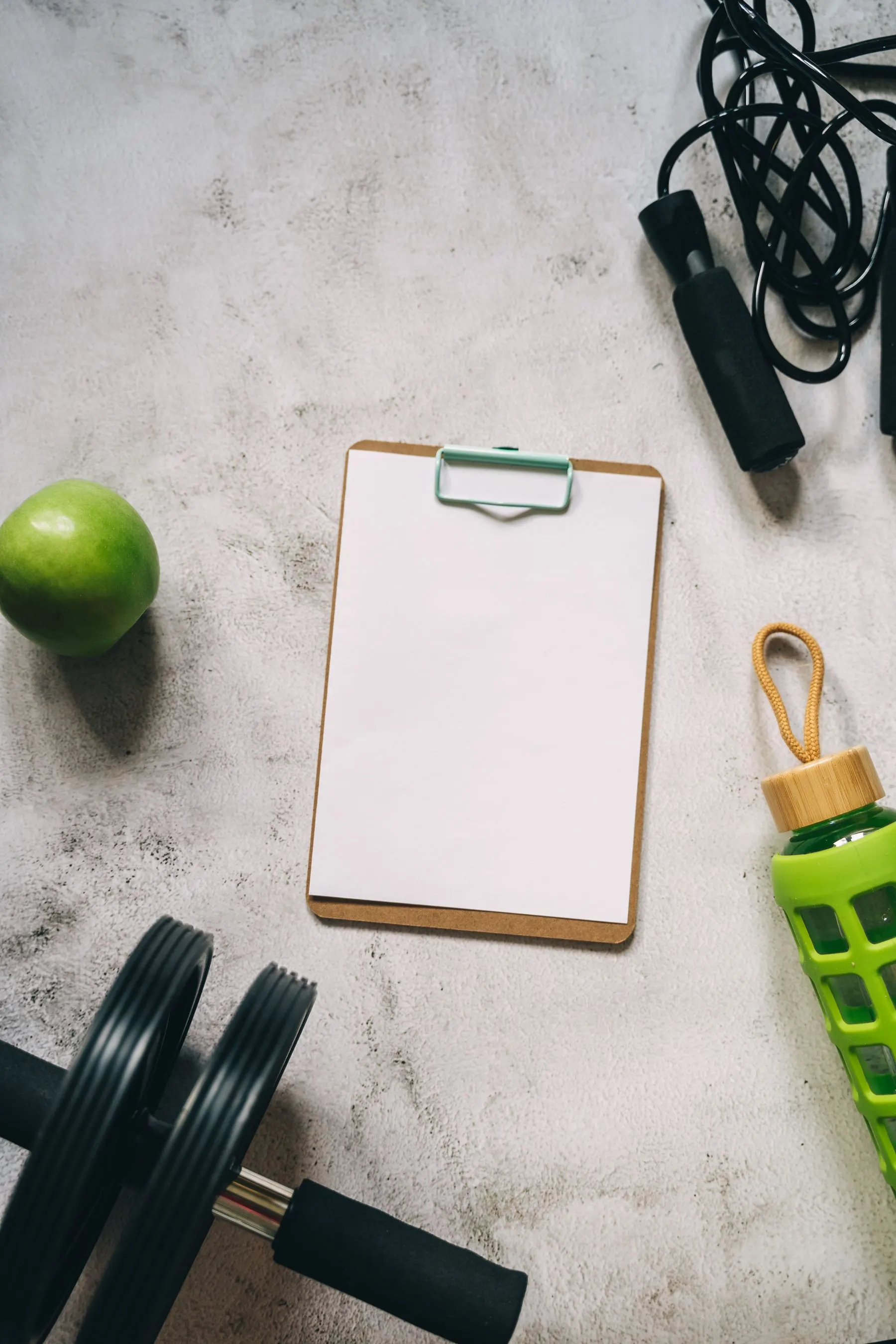 Workout equipment arranged around a blank clipboard for vocabulary notes.