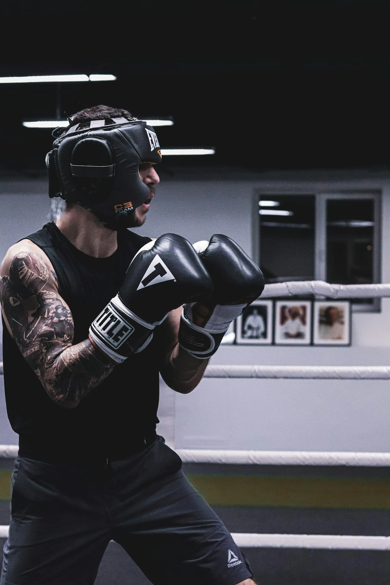 Boxer wearing gloves and protective headgear in a ring.