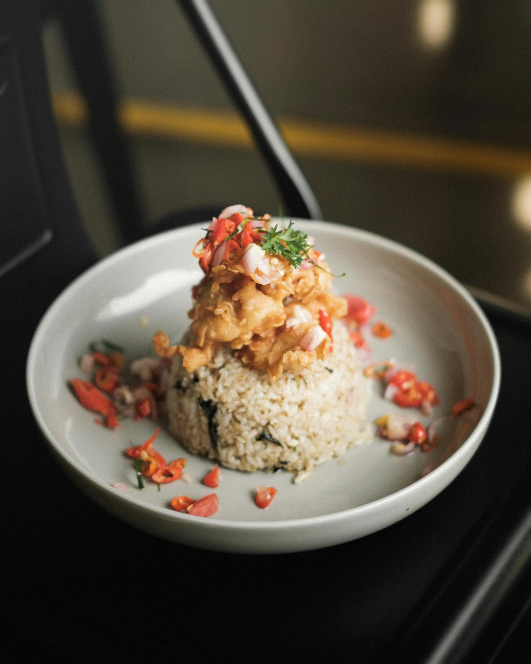 Rice dish topped with vegetables and protein-rich ingredients.