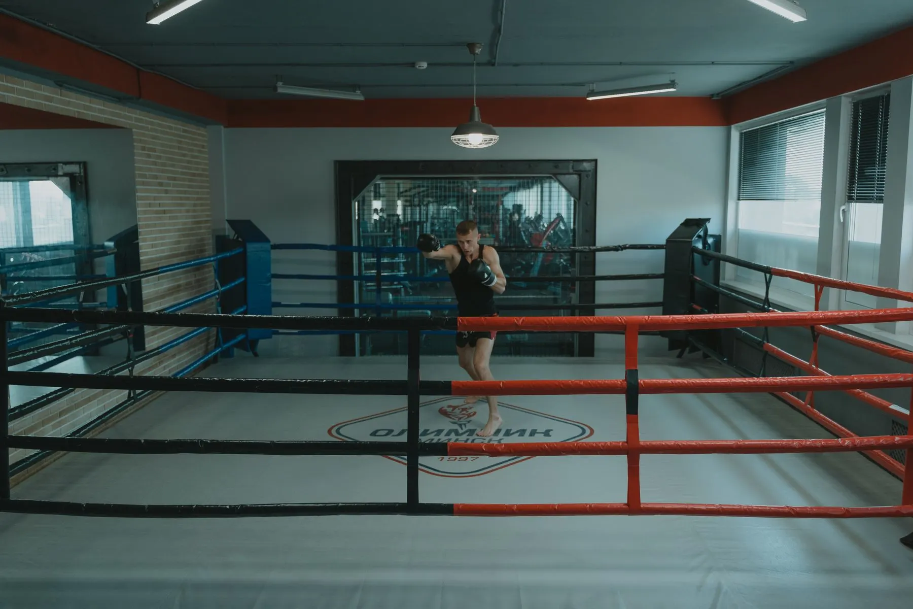 A boxer practising alone with clear space around him in a boxing ring.
