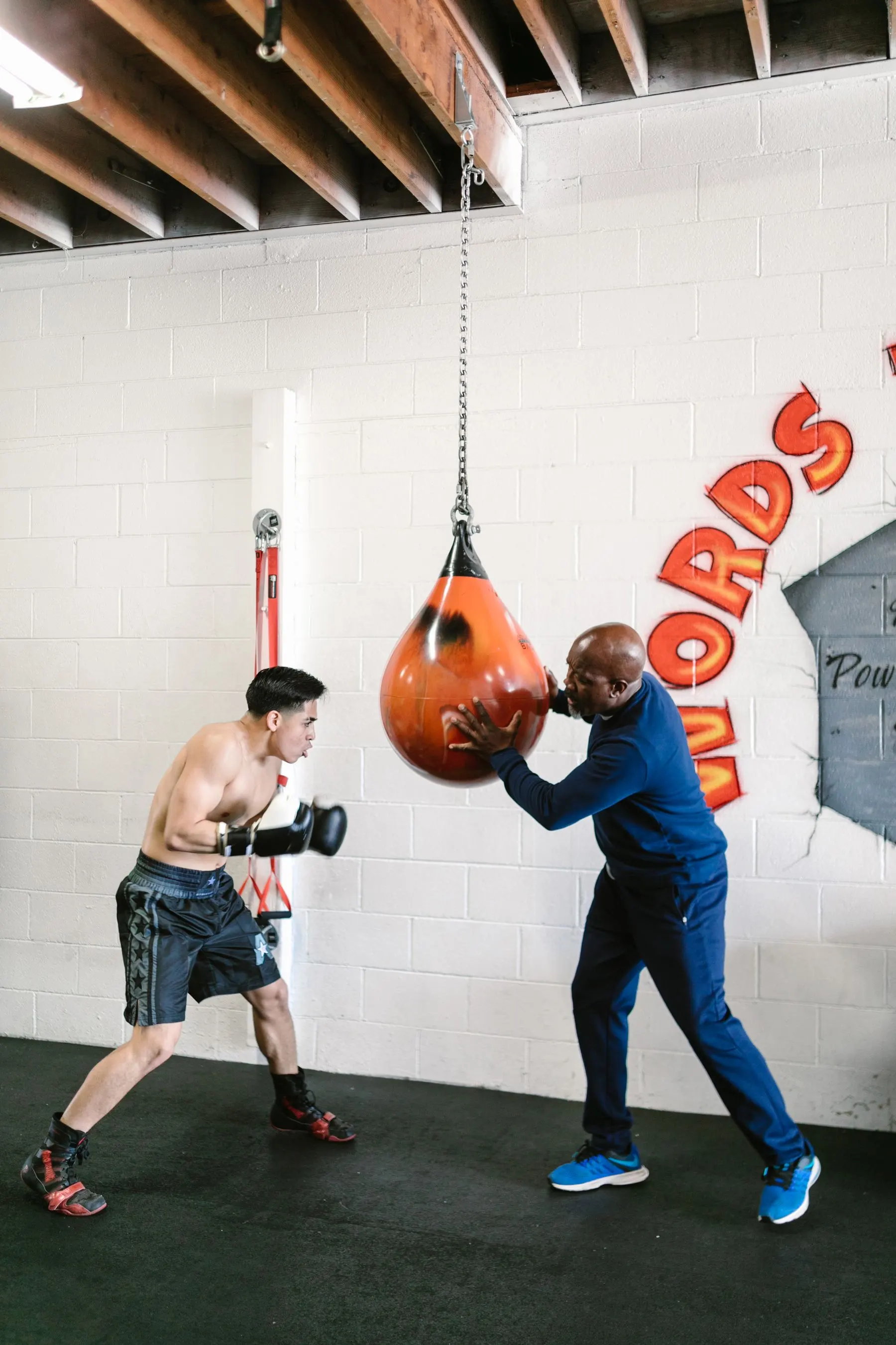 Coach observing a boxer during a focused technique drill.