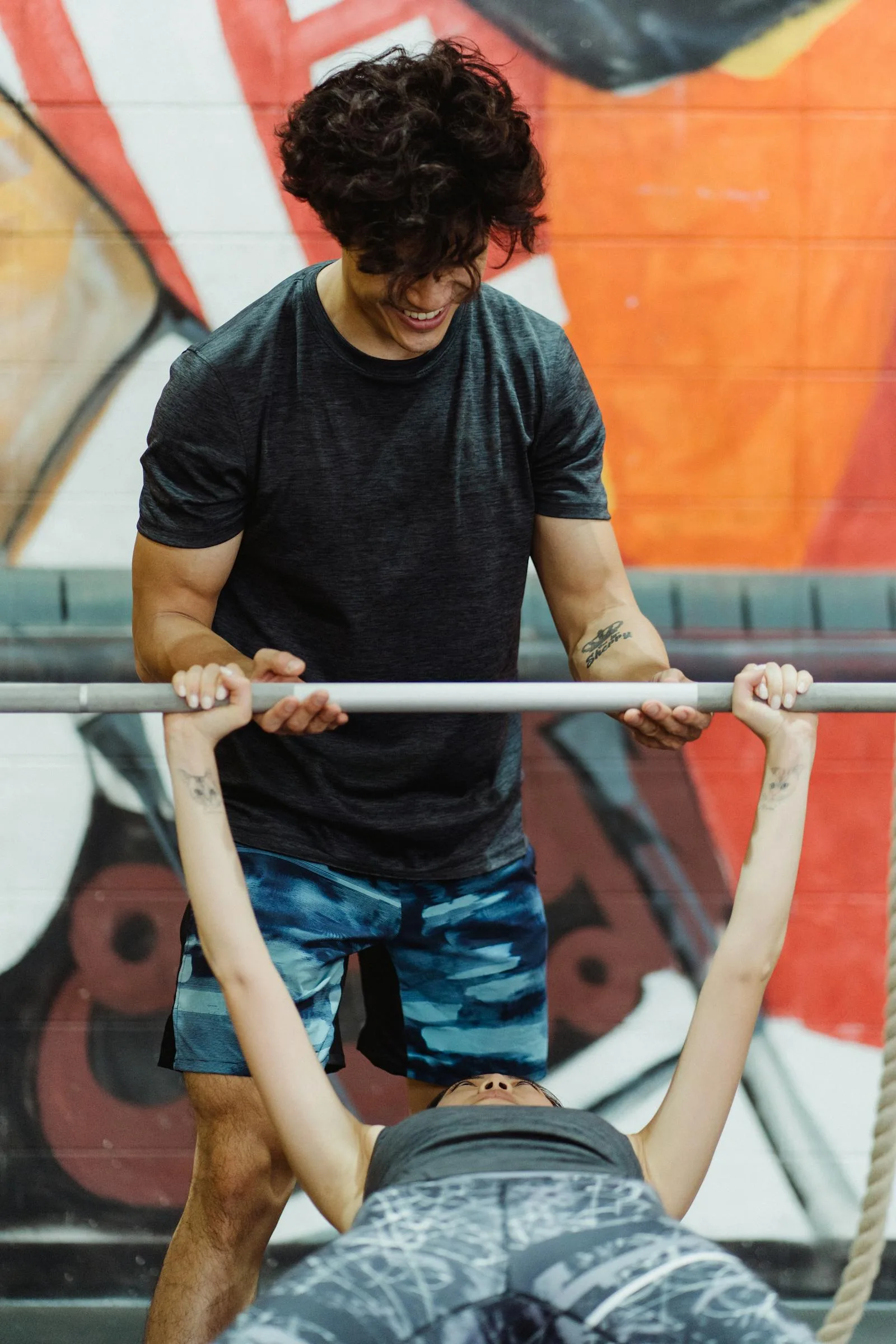 Woman bench pressing with help from a coach.