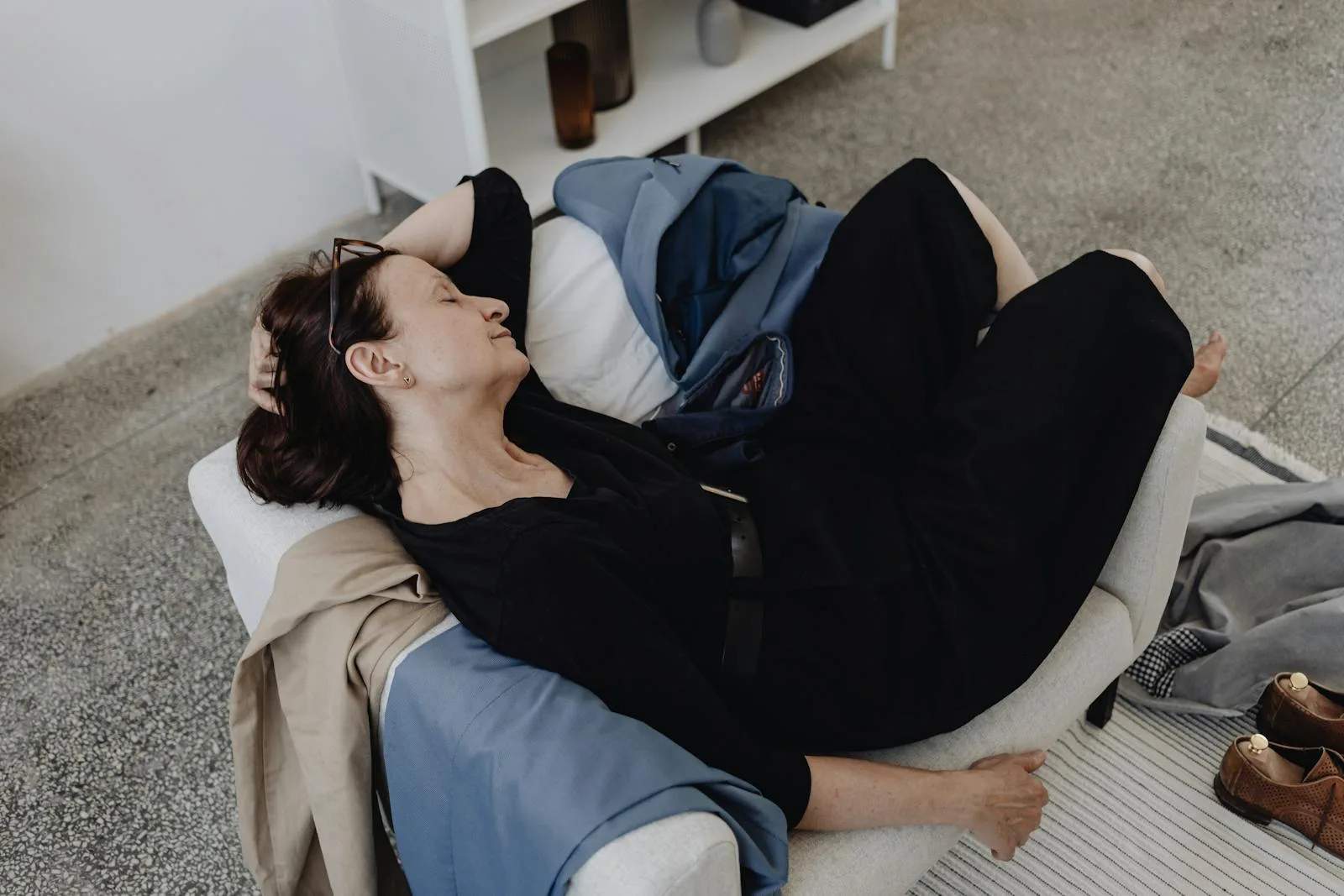 Tired person sleeping on a sofa after a long day.