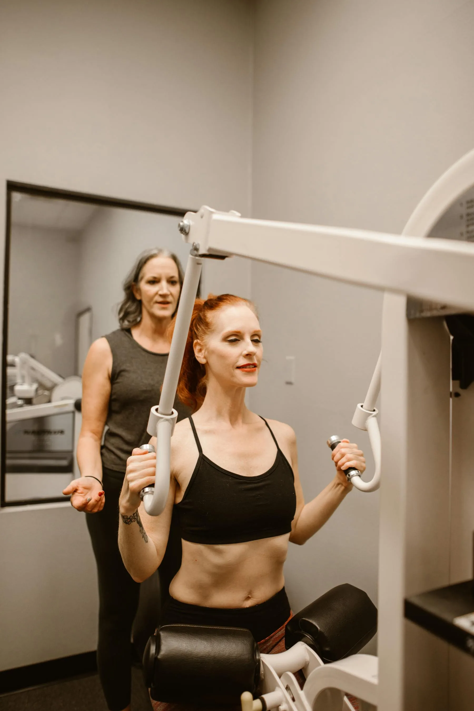 Women training on gym machines with focused effort.