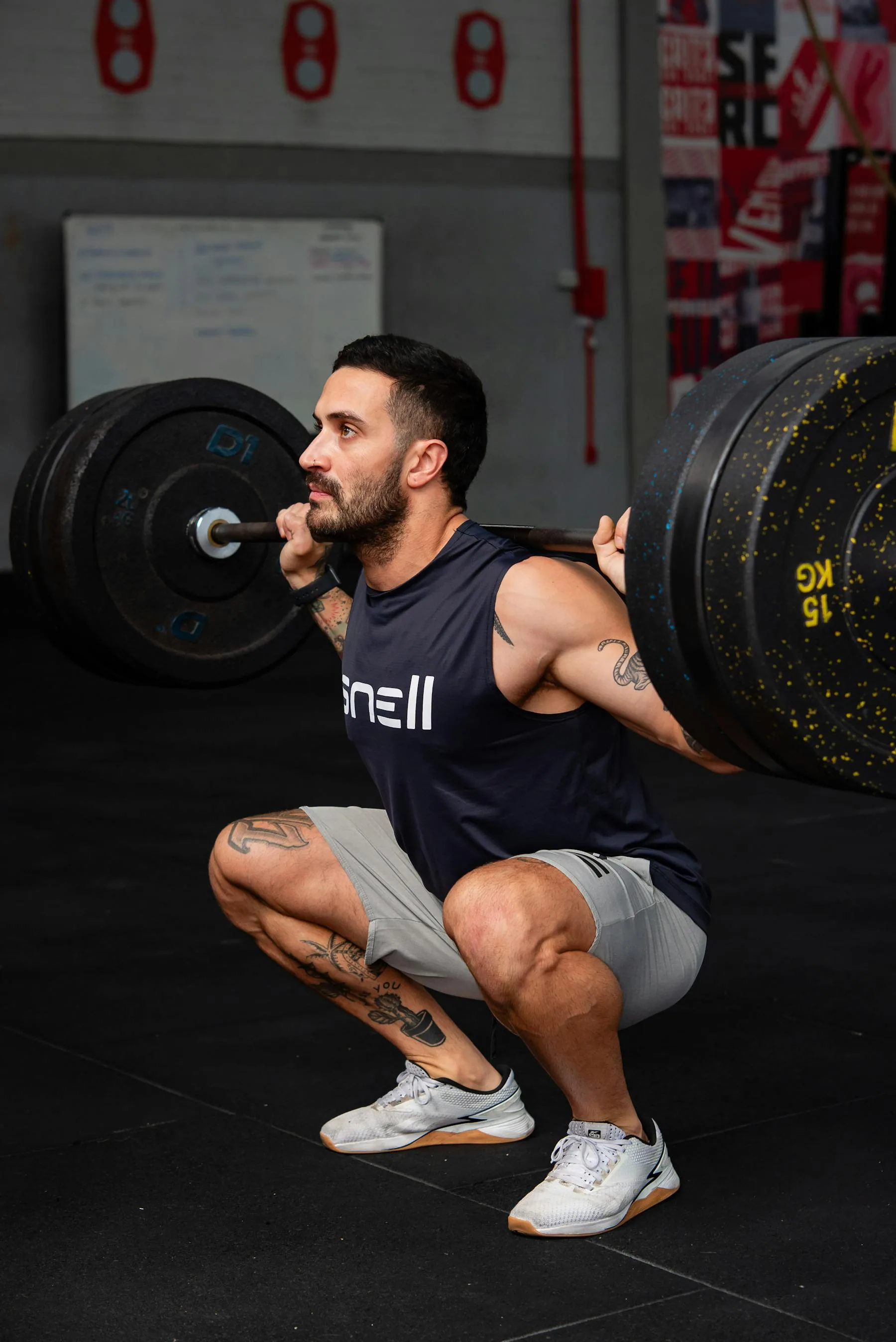 Man performing a heavy barbell squat in a gym.
